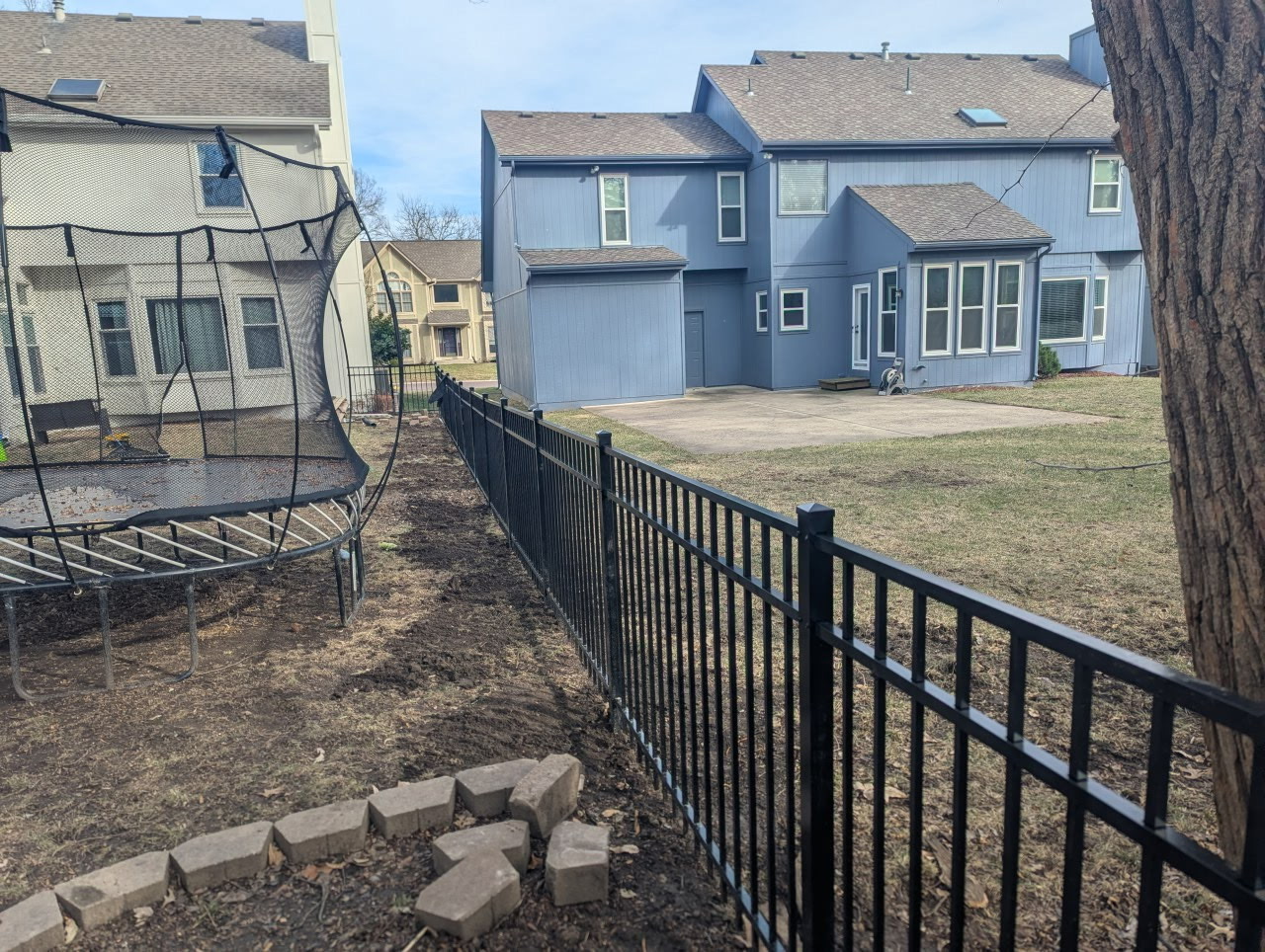 4 ft flat-top black aluminum fence enclosing a backyard with trampoline and patio — Overland Park, KS