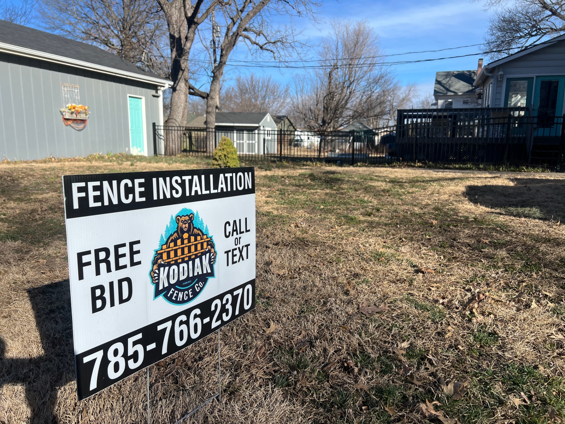 Kodiak Fence Company yard sign in front of a freshly installed 5 ft black ornamental aluminum fence on a Kansas City residential job site